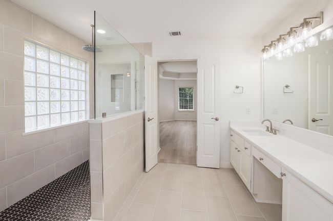 Full bath featuring walk-in shower with rainfall feature and shower wand. Double vanity quartz countertops | Image 21