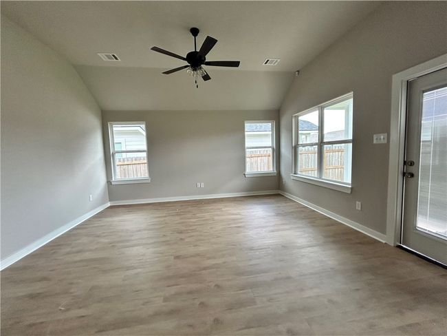 Living room with wood-finished flooring and a ceiling fan | Image 5