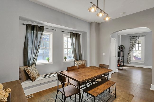 dining space featuring baseboards, visible vents, arched walkways, and dark wood finished floors | Image 10
