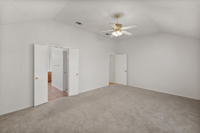 Spacious Primary Bedroom with lofted ceiling and carpet floors | Image 12