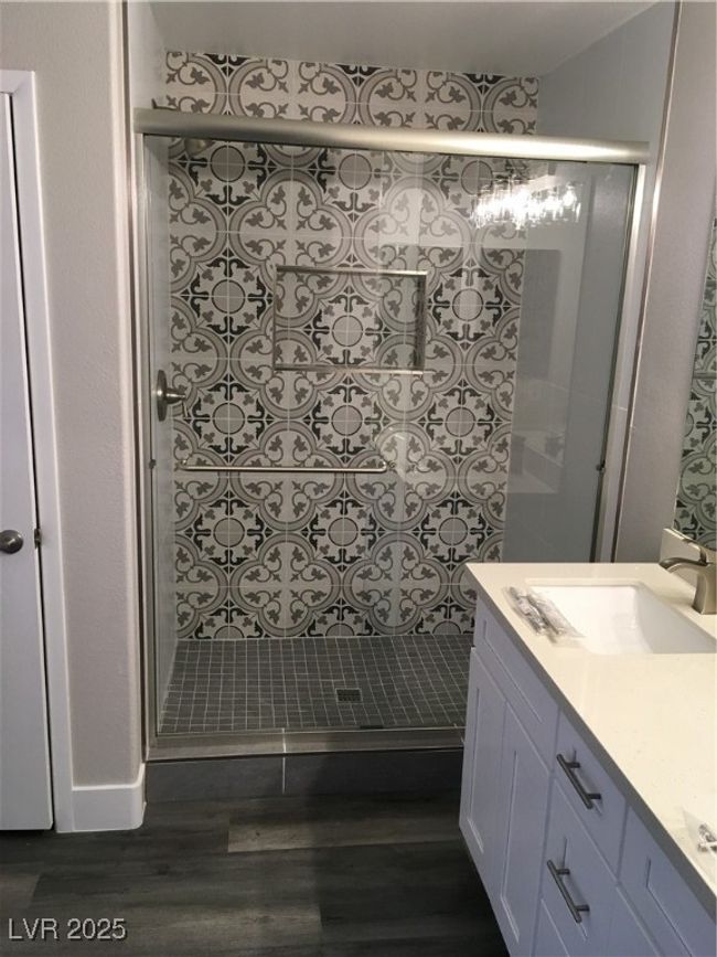 Bathroom with a stall shower, wood finished floors, and vanity | Image 24