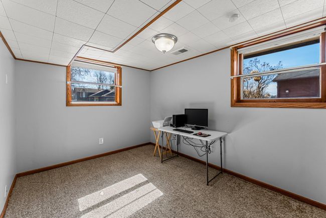 A versatile den, located just steps away, offers many possibilities—it can serve as an additional living area, home office, or even a fourth bedroom. It includes lookout windows and comfortable carpeting. | Image 16