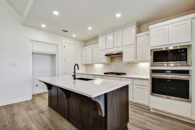 Kitchen featuring appliances with stainless steel finishes, white cabinets, tasteful backsplash, and recessed lighting | Image 6