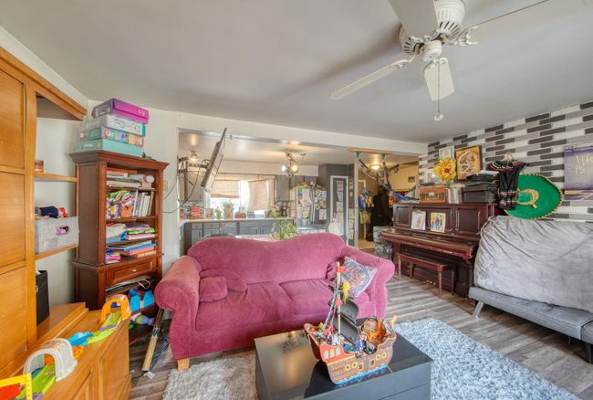 Living room with wood finished floors and a ceiling fan | Image 7