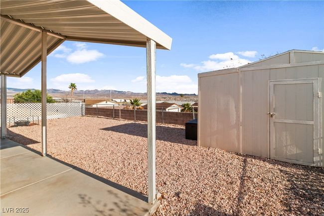 View of yard featuring a storage shed, a patio, a fenced backyard, an outbuilding, and a mountain view | Image 36