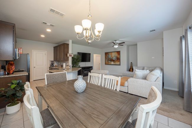 Dining space with light tile patterned floors, a ceiling fan, a chandelier, and recessed lighting | Image 15