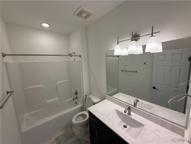 Bathroom featuring toilet, vanity, and shower / tub combination | Image 16