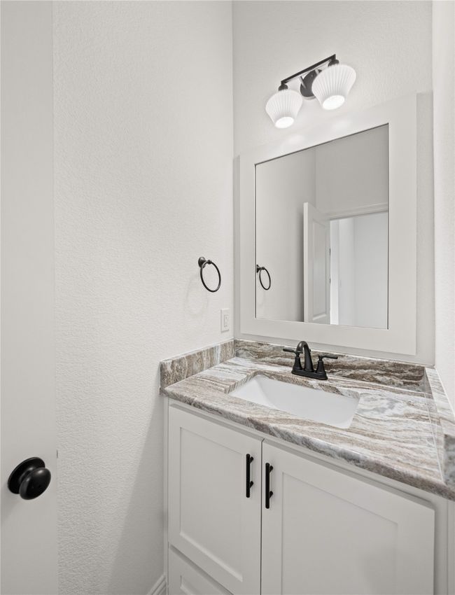 Bathroom featuring vanity and a textured wall | Image 25