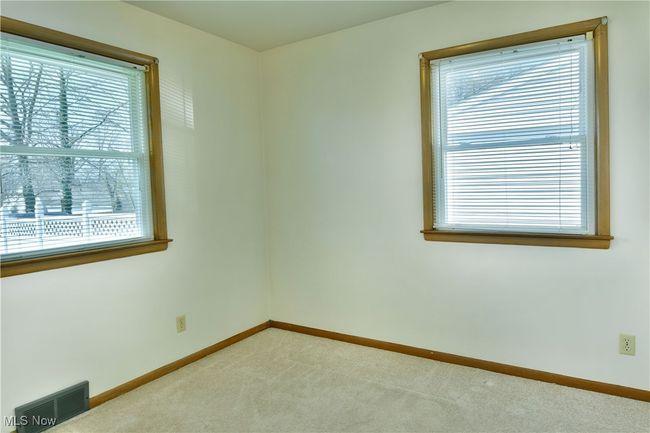 Empty room with baseboards, plenty of natural light, visible vents, and light colored carpet | Image 23