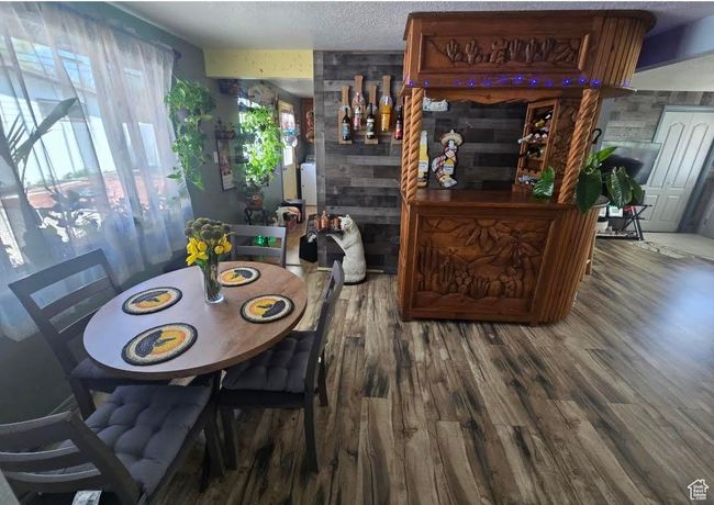 Dining room with wood finished floors and a textured ceiling | Image 6