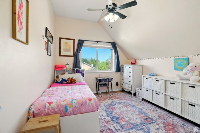 Bedroom featuring vaulted ceiling, a ceiling fan, and baseboards | Image 24