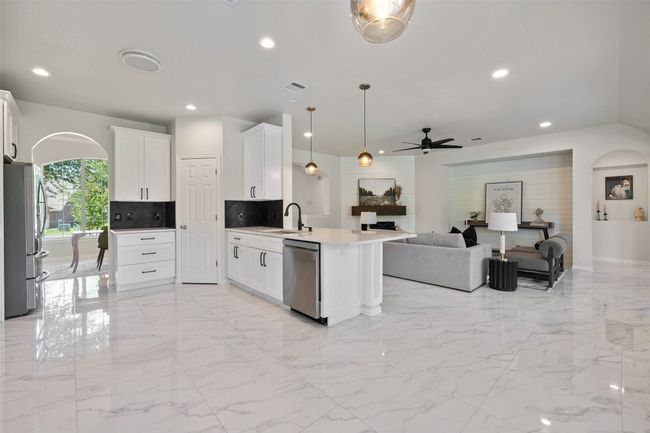Kitchen appliances with stainless steel finishes, open floor plan, a peninsula, ceiling fan, and arched walkways | Image 14