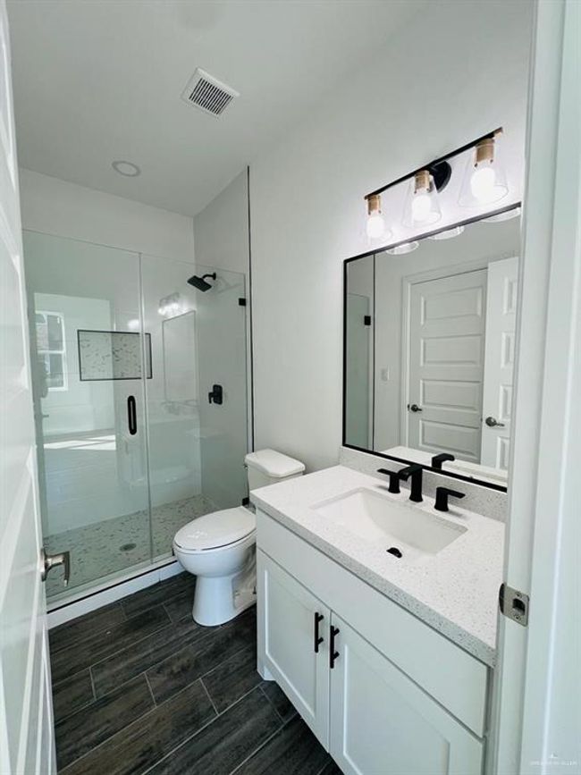 Bathroom with vanity, toilet, and an enclosed shower | Image 15