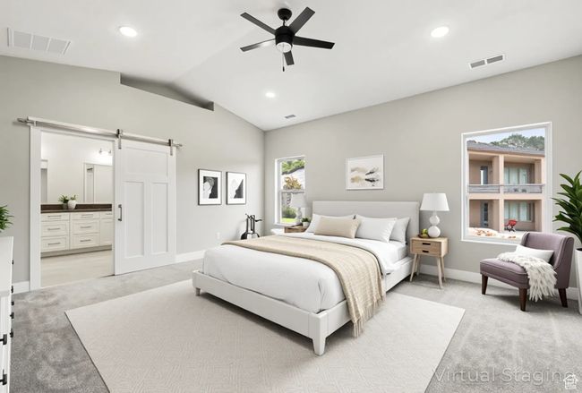 Bedroom featuring a barn door, light colored carpet, vaulted ceiling, baseboards, and connected bathroom | Image 24