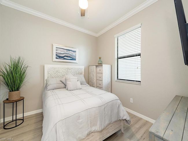 Bedroom featuring baseboards, a ceiling fan, light wood-style flooring, and crown molding | Image 8