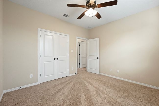 Unfurnished bedroom featuring light carpet, a closet, and a ceiling fan | Image 23
