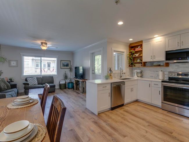 Kitchen featuring open shelves, a sink, open floor plan, appliances with stainless steel finishes, and ornamental molding | Image 6