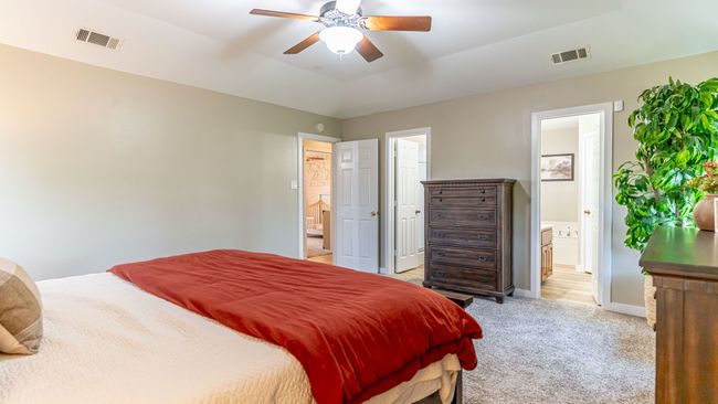 Bedroom featuring light carpet, ensuite bath, and visible vents | Image 20