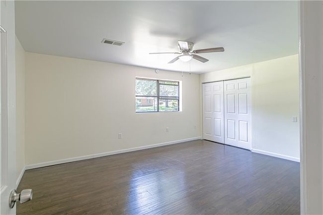 Unfurnished bedroom with dark hardwood / wood-style flooring, ceiling fan, and a closet | Image 38