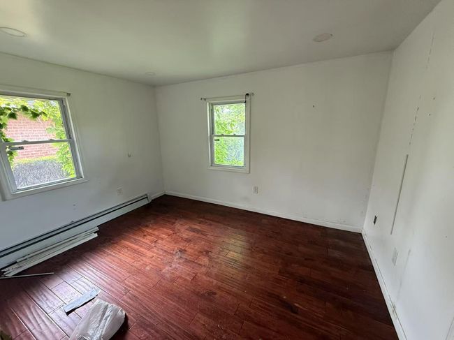 Spare room featuring baseboard heating and hardwood / wood-style floors | Image 7