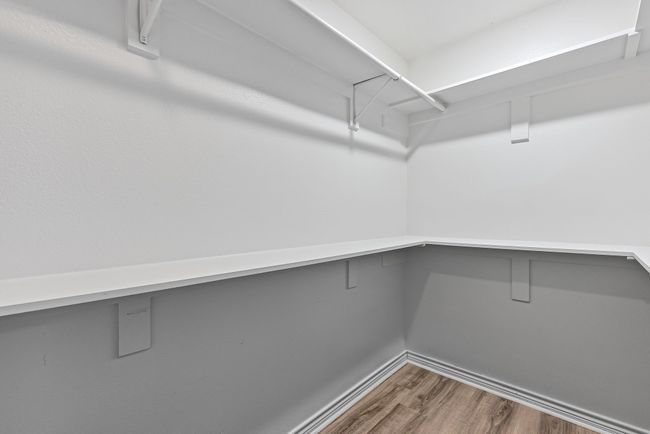 Primary closet with wood finished floors | Image 15