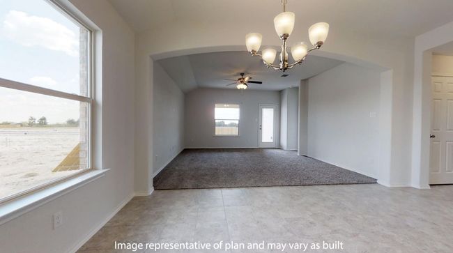 Spare room featuring arched walkways, ceiling fan, a chandelier, carpet, and baseboards | Image 10