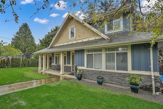 View of front of property with stone siding, roof with shingles, board and batten siding, and a front yard | Image 26