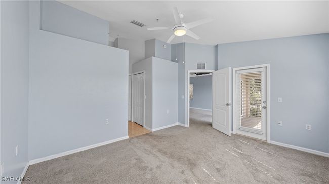 Unfurnished bedroom with carpet floors, access to exterior, visible vents, and lofted ceiling | Image 13