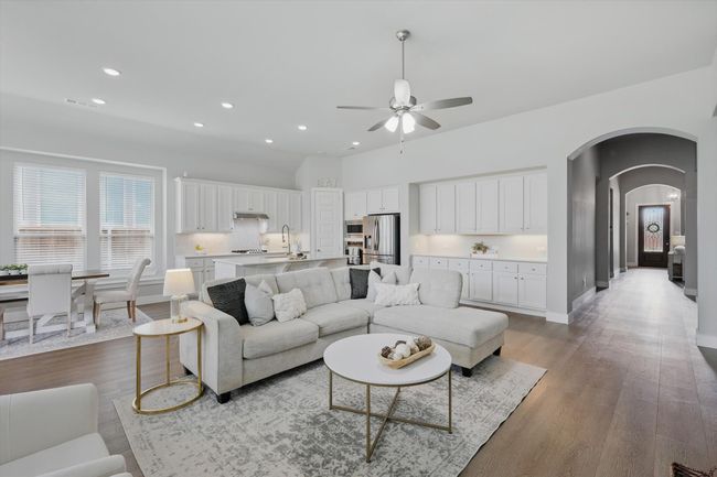 Living area featuring ceiling fan, arched walkways, light wood-type flooring, and recessed lighting | Image 4