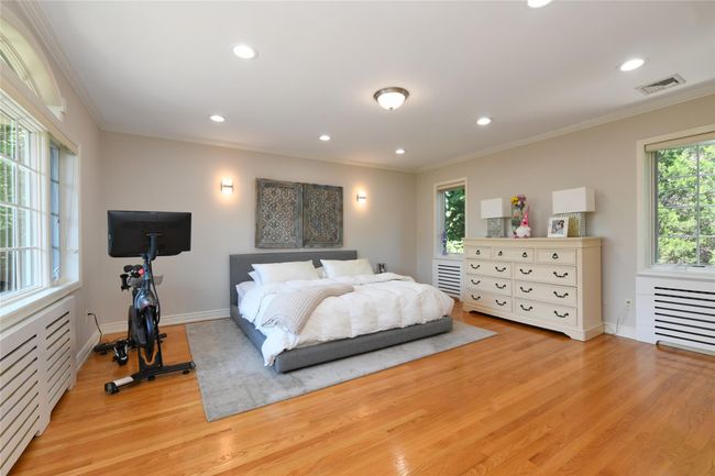 Bedroom featuring light wood-type flooring, visible vents, and ornamental molding | Image 12