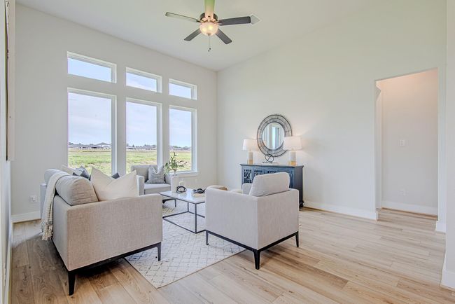 Relax in a sun-drenched living room with soaring ceilings and a wall of windows that capture peaceful neighborhood and water views. | Image 18