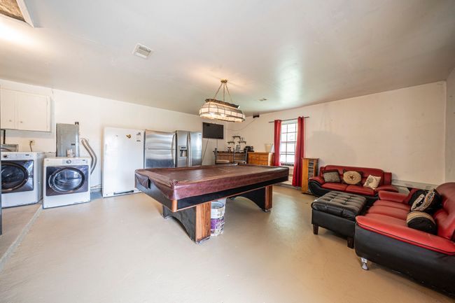 Recreation room with washer and dryer, concrete flooring, billiards table, and electric panel | Image 23