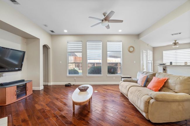 Living area featuring ceiling fan, arched walkways, dark wood-style flooring, and recessed lighting | Image 12