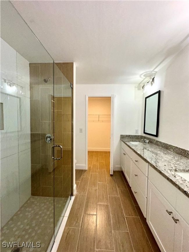 Bathroom featuring a shower with shower door and vanity | Image 14