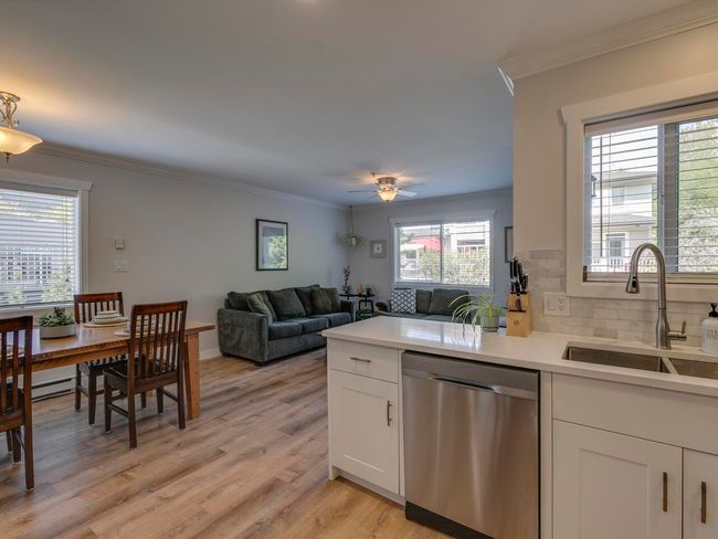 Kitchen featuring dishwasher, crown molding, white cabinetry, and a sink | Image 9