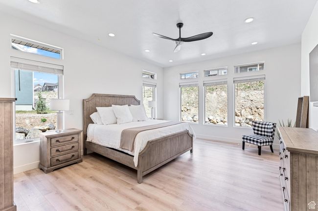 Bedroom featuring light wood-style floors, multiple windows, and recessed lighting | Image 19
