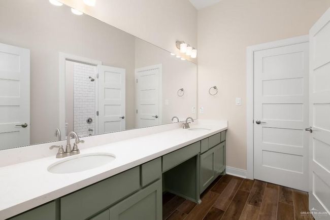 Full bath featuring a sink, a tile shower, double vanity, and wood finished floors | Image 14