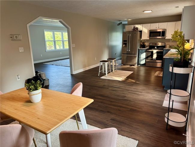 Dining room featuring arched walkways, baseboards, and dark wood finished floors | Image 9