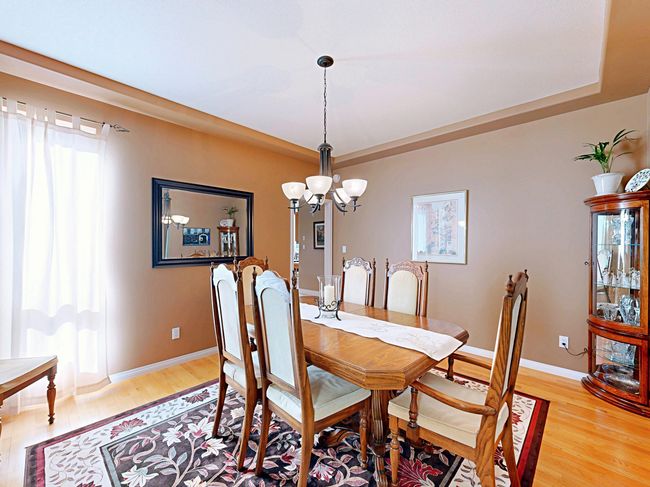 Dining space with a chandelier, light wood-style floors, and a tray ceiling | Image 13