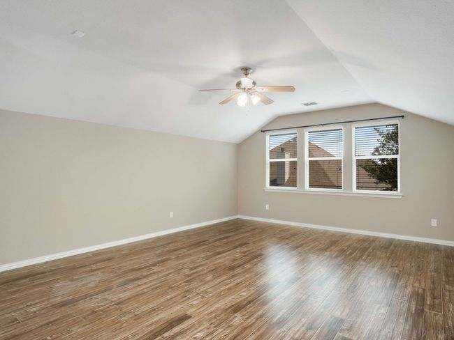 Additional living space featuring ceiling fan, vaulted ceiling, and wood finished floors | Image 32