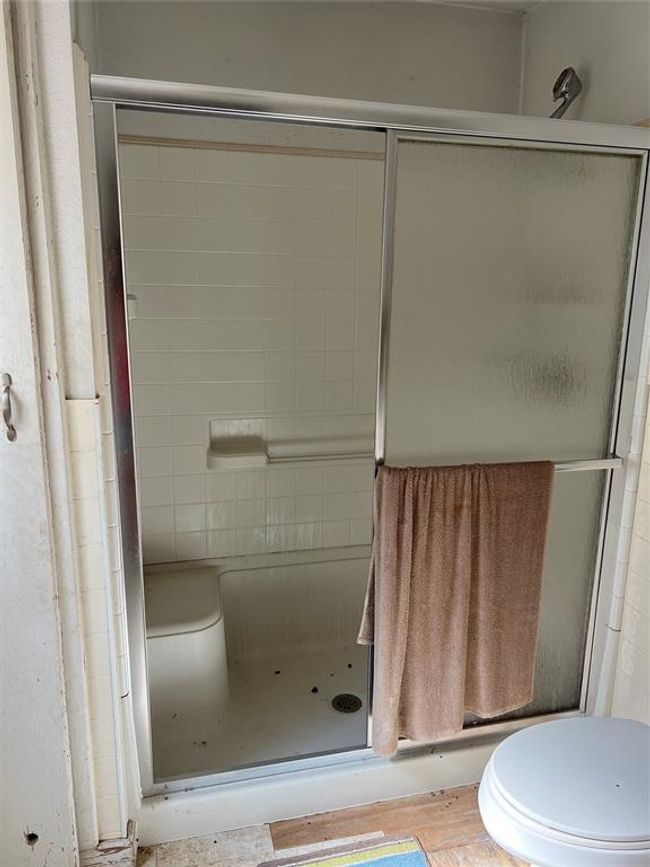 Bathroom with toilet and a shower with door | Image 21