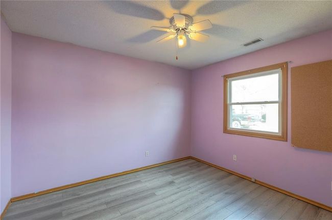 Empty room featuring light wood-type flooring, a textured ceiling, baseboards, and visible vents | Image 15