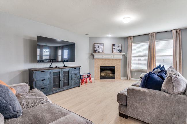 Living room with wood finished floors and a tile fireplace. | Image 18