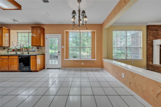 Kitchen with plenty of natural light, brown cabinetry, a chandelier, and dishwasher | Image 7