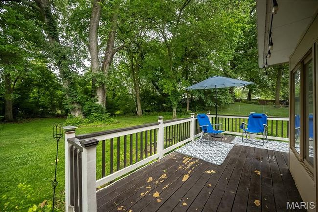 Deck with a yard and view of wooded area | Image 32