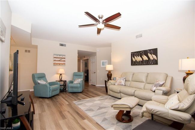 Casual and comfortable living room with ample space for furniture and decor. | Image 10