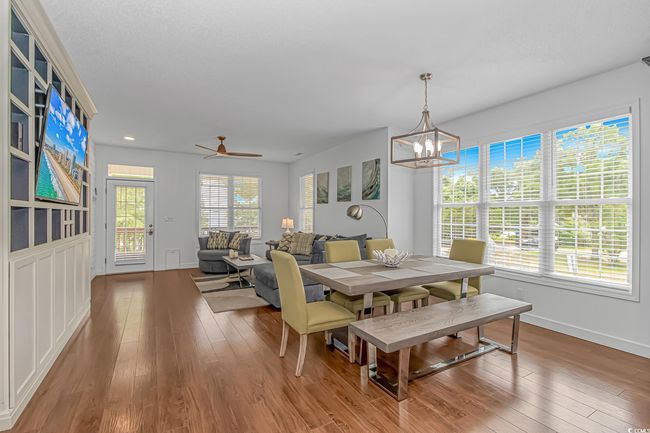 Dining area featuring wood finished floors, a chandelier, and baseboards | Image 9