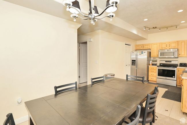 Dining area featuring a notable chandelier, rail lighting, baseboards, and recessed lighting | Image 17