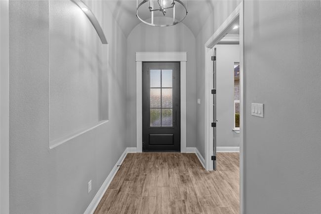 Entryway with wood finished floors and a chandelier | Image 4