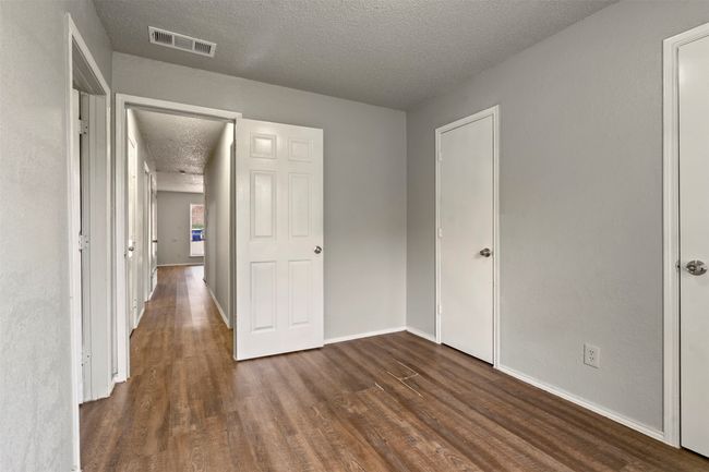 Unfurnished bedroom featuring a textured ceiling, dark wood-type flooring, and baseboards | Image 20